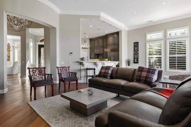 living room with a chandelier, crown molding, and hardwood / wood-style flooring