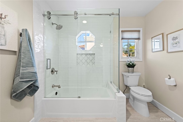 bathroom featuring hardwood / wood-style flooring, plenty of natural light, toilet, and combined bath / shower with glass door