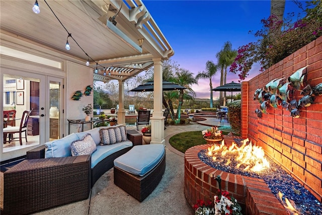 patio terrace at dusk with french doors, a pergola, and an outdoor living space with a fire pit