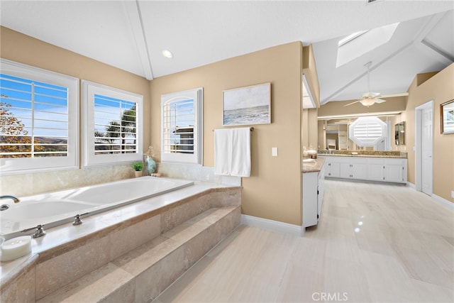 bathroom featuring vanity, tiled tub, plenty of natural light, and lofted ceiling