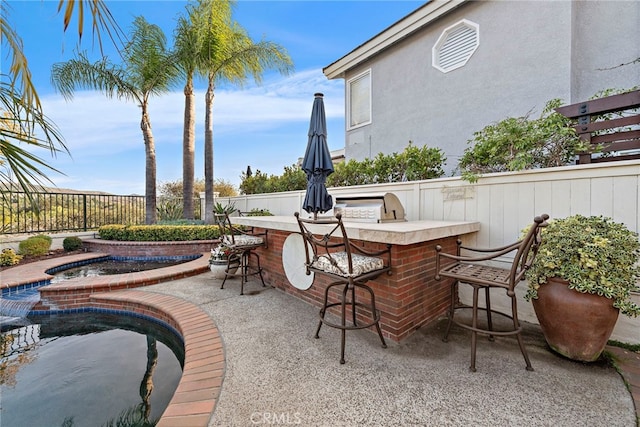 view of patio featuring an in ground hot tub, a bar, and area for grilling