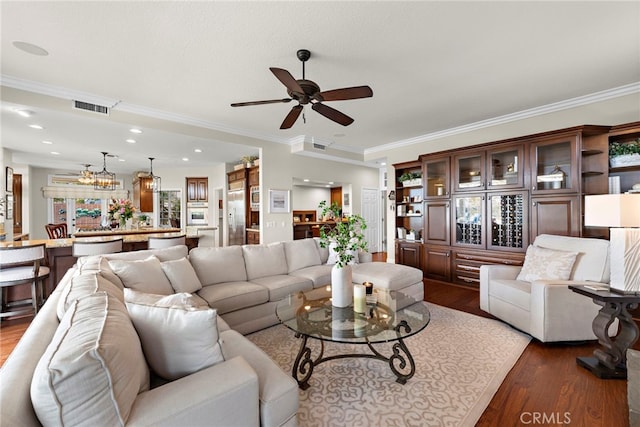 living room with dark hardwood / wood-style floors, ceiling fan, and ornamental molding