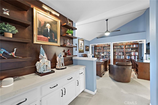 kitchen featuring ceiling fan, light colored carpet, white cabinets, and vaulted ceiling