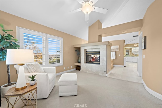 carpeted living room with ceiling fan, a multi sided fireplace, and lofted ceiling