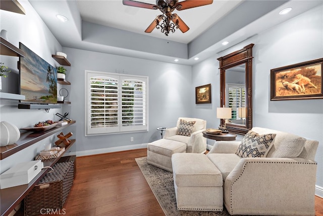 living room with dark wood-type flooring and ceiling fan