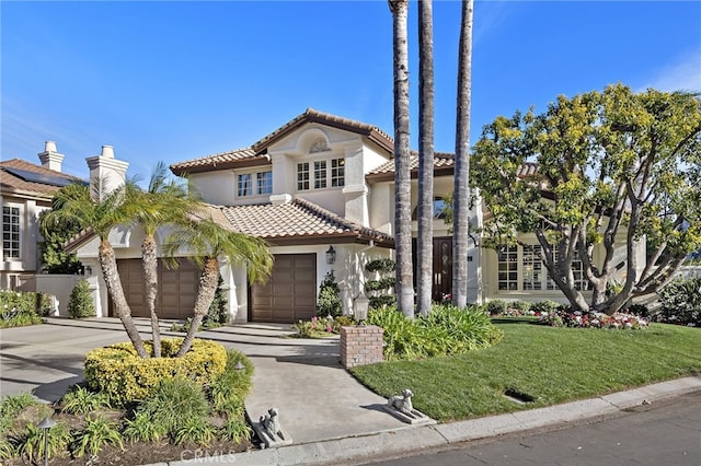 mediterranean / spanish-style house featuring a garage and a front yard