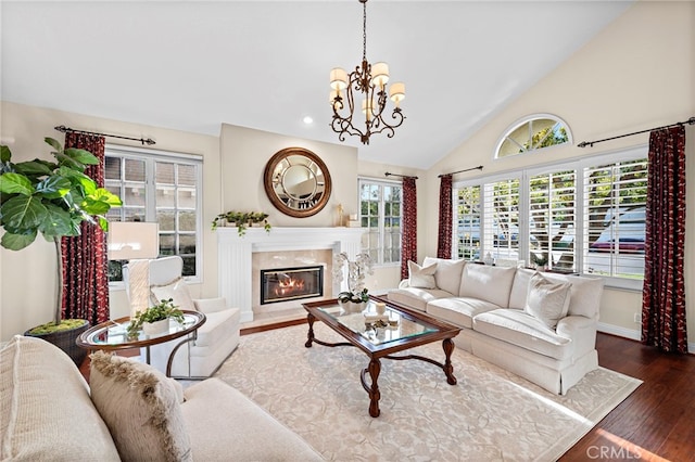 living room featuring a premium fireplace, vaulted ceiling, a notable chandelier, and dark hardwood / wood-style floors