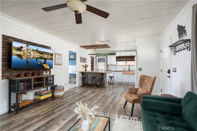 living room featuring hardwood / wood-style flooring, crown molding, and ceiling fan