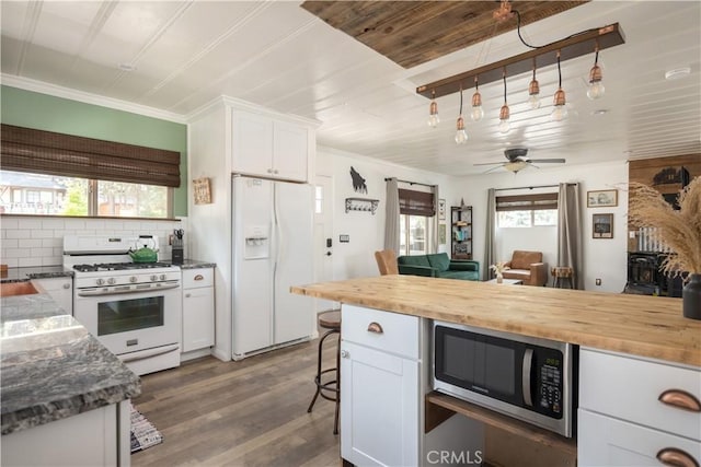 kitchen with dark hardwood / wood-style floors, ceiling fan, white cabinets, and white appliances