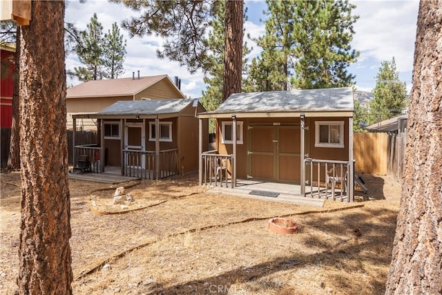 rear view of property featuring a storage shed