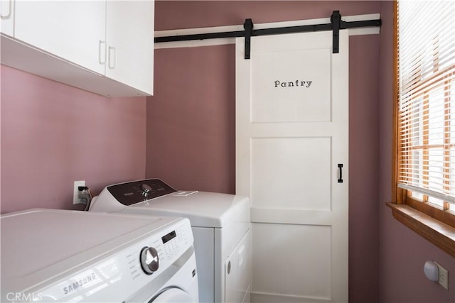 washroom featuring washer and dryer, cabinets, and a barn door