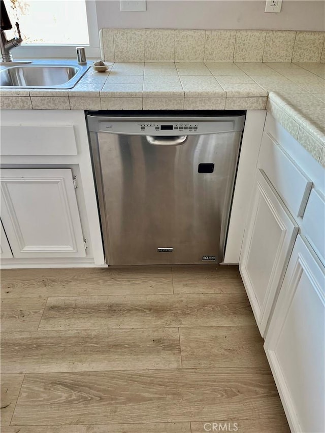 details featuring dishwasher, sink, white cabinets, and light hardwood / wood-style floors