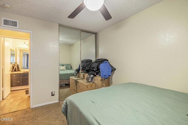 carpeted bedroom featuring a textured ceiling, ceiling fan, and a closet