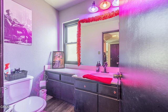 bathroom with toilet, wood-type flooring, and vanity