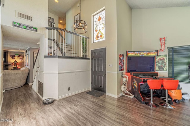 interior space featuring a high ceiling, an inviting chandelier, and hardwood / wood-style floors