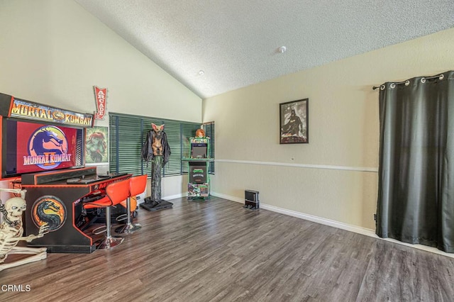 recreation room featuring lofted ceiling, wood-type flooring, and a textured ceiling