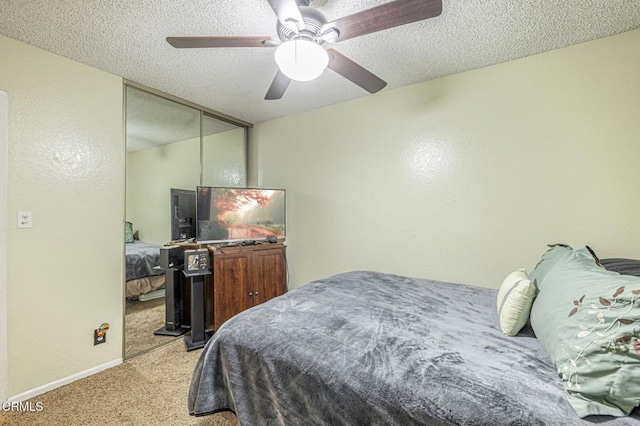 bedroom featuring a textured ceiling, baseboards, a ceiling fan, and light colored carpet