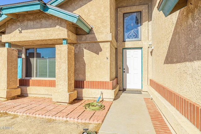 view of exterior entry with stucco siding