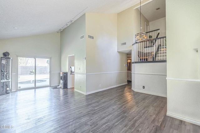 unfurnished living room featuring baseboards, visible vents, and dark wood finished floors