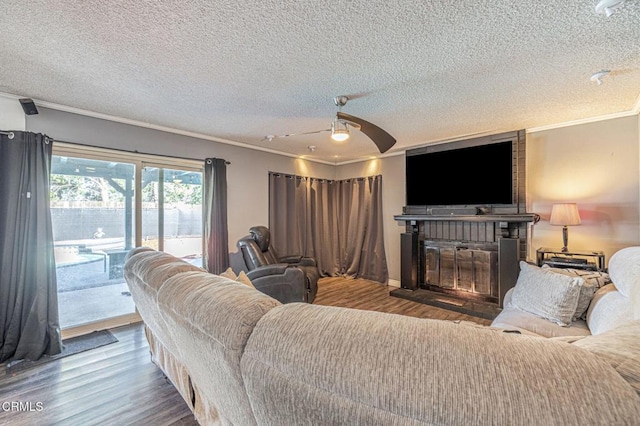 living area featuring a textured ceiling, wood finished floors, and crown molding