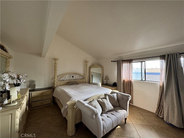 bedroom with dark tile patterned floors, a water view, and vaulted ceiling