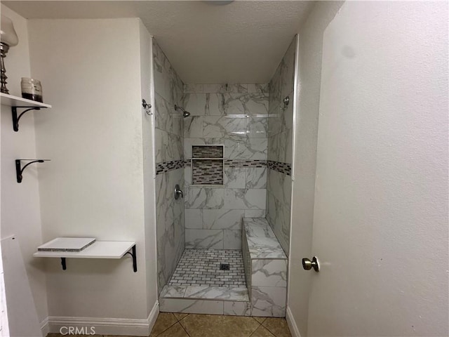 bathroom with tile patterned flooring and a tile shower