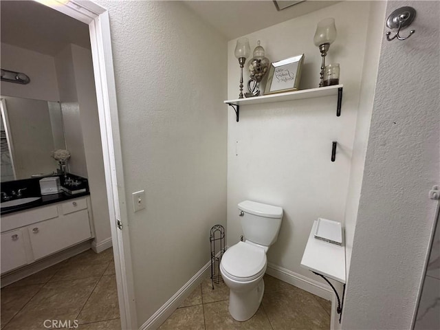 bathroom with toilet, tile patterned flooring, and vanity