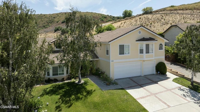 view of front of home with a front yard, a mountain view, and a garage