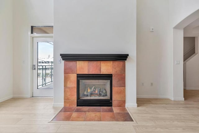 details featuring hardwood / wood-style floors and a tiled fireplace