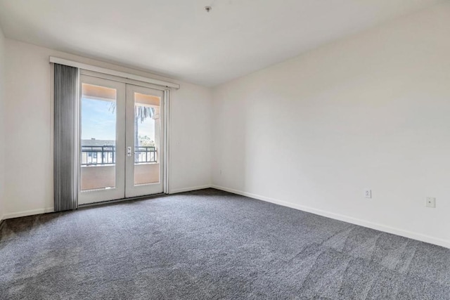 carpeted spare room featuring french doors