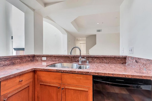 kitchen with light stone counters, sink, and dishwasher