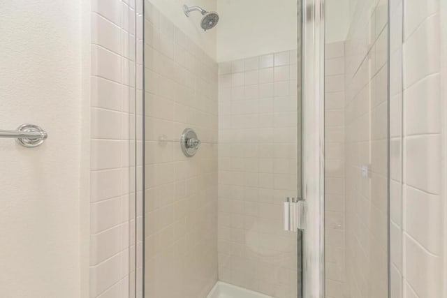 bathroom with a shower with door