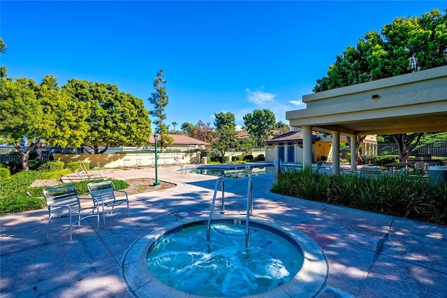 view of swimming pool featuring a community hot tub and a patio area