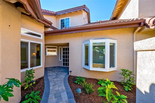 view of exterior entry with a patio area