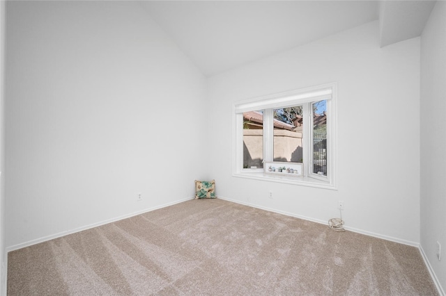 spare room with vaulted ceiling and carpet floors