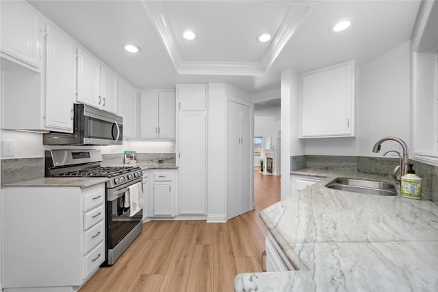 kitchen featuring appliances with stainless steel finishes, a tray ceiling, and white cabinetry