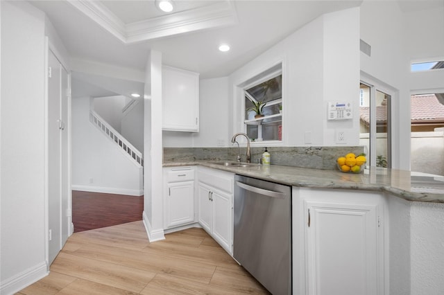 kitchen with light hardwood / wood-style floors, a raised ceiling, stainless steel dishwasher, white cabinets, and sink