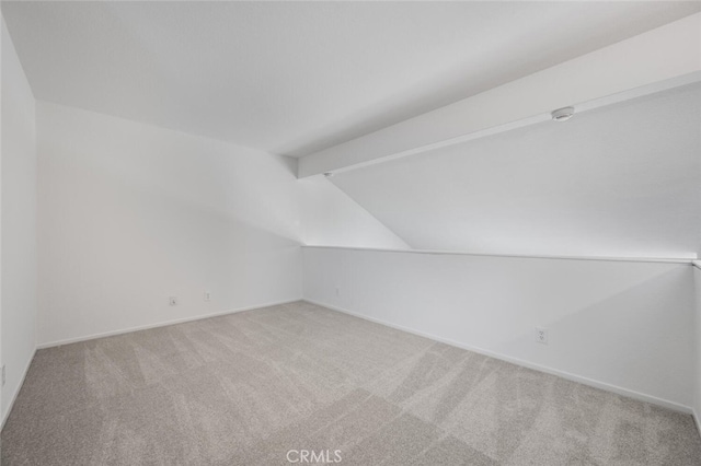 additional living space featuring carpet floors and lofted ceiling with beams