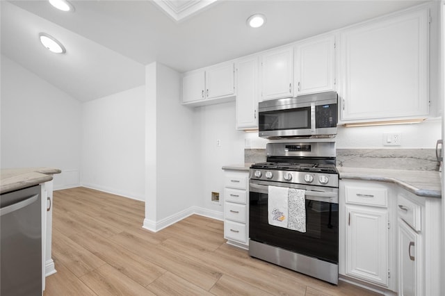 kitchen featuring stainless steel appliances, light hardwood / wood-style flooring, white cabinetry, and light stone countertops