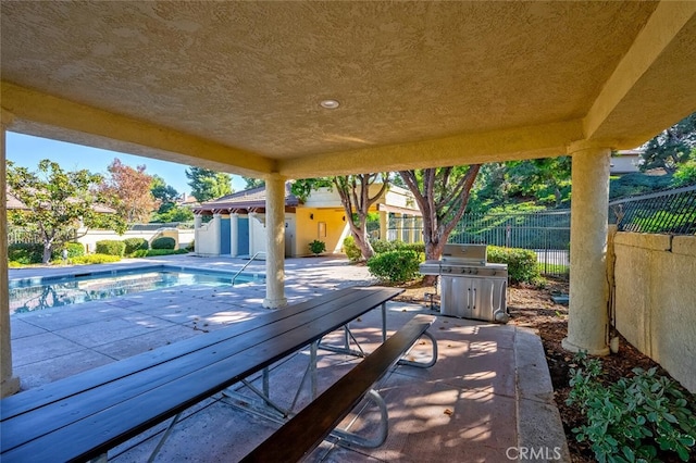 view of patio with a fenced in pool and area for grilling