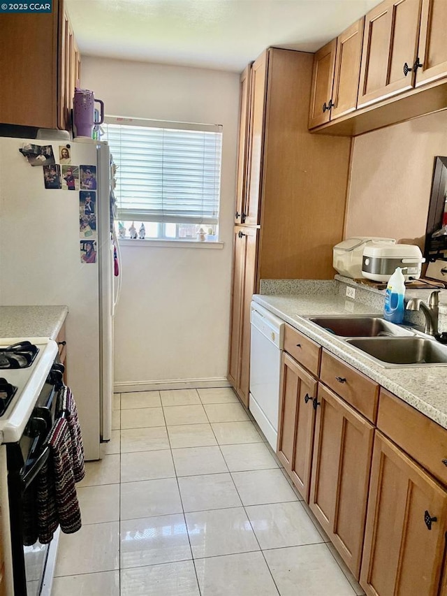 kitchen with white dishwasher, sink, light tile patterned floors, and gas range