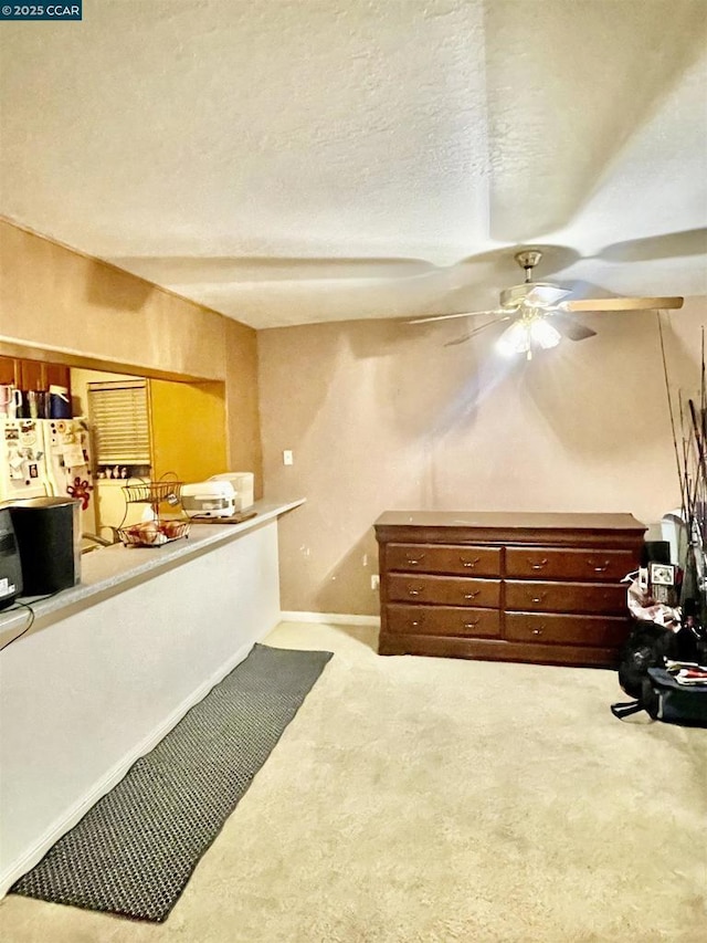 carpeted bedroom with ceiling fan and a textured ceiling