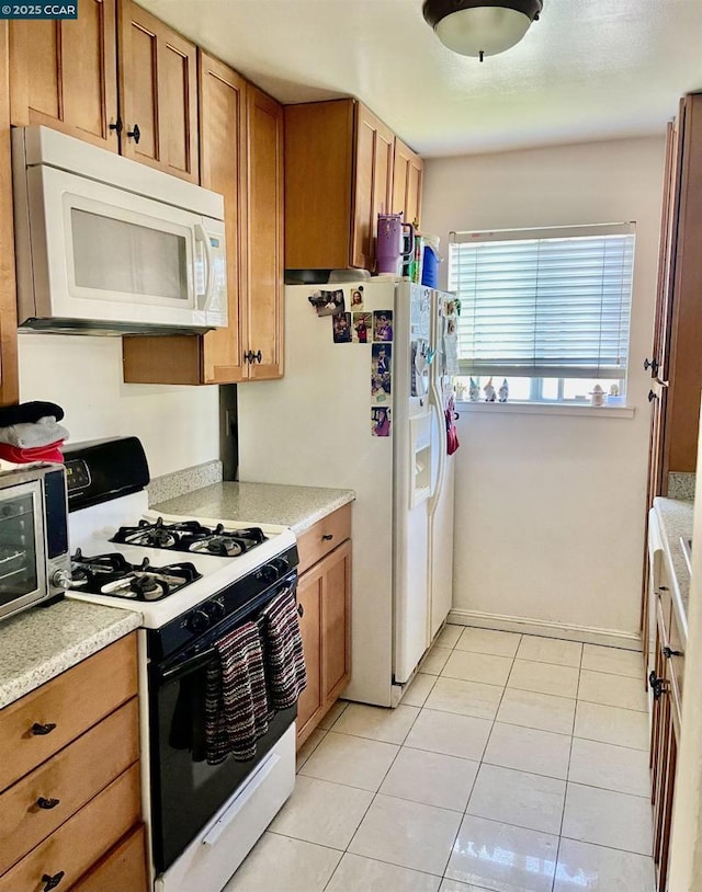 kitchen featuring light tile patterned floors and white appliances