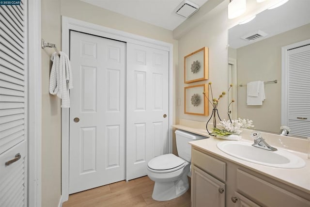 bathroom featuring vanity, toilet, and hardwood / wood-style floors