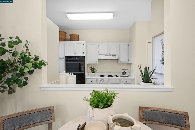 kitchen featuring black double oven, white cabinets, and white electric stovetop