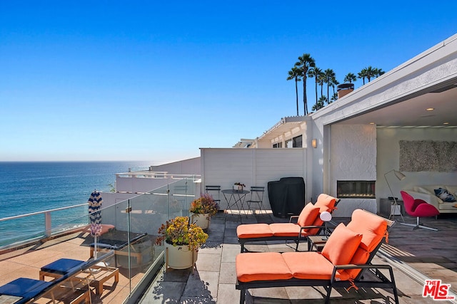 view of patio featuring a balcony and a water view