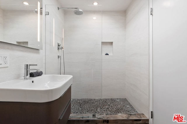 bathroom with vanity and tiled shower