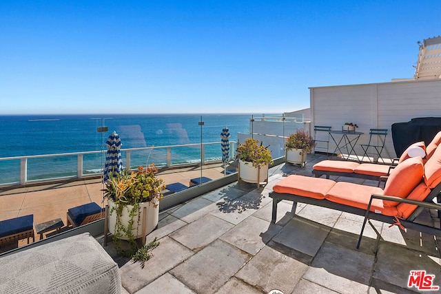 view of patio with a water view and a balcony