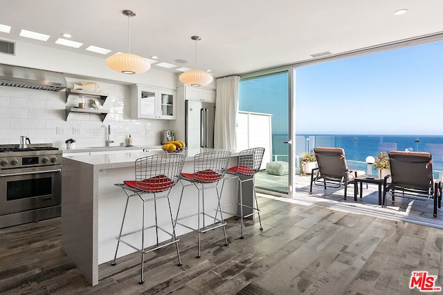 kitchen featuring a kitchen breakfast bar, white cabinetry, a water view, and high quality appliances