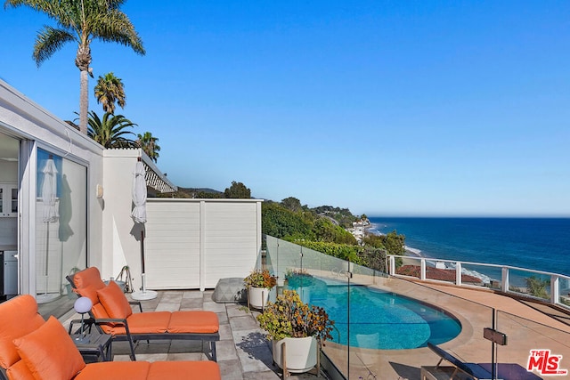 view of pool with a patio area and a water view